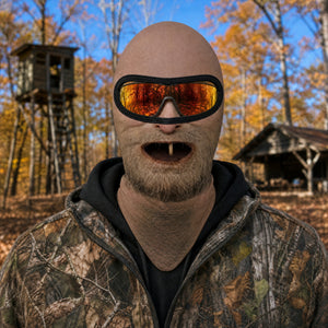 One Tooth Willie full face balaclava worn with orange goggles over the eye opening, printed nose, dropped jaw and one tooth, hunting camp